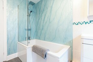 Bathroom features a glass-enclosed shower and a bathtub with a handheld shower attachment.