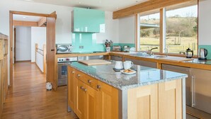 Een moderne keuken met houten kastjes, een granieten aanrechtblad en uitzicht op de omgeving.