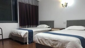 A hotel room with two beds, a window with curtains, a wall-mounted light fixture, and a wooden floor. - MiaoJu (Yueqing)