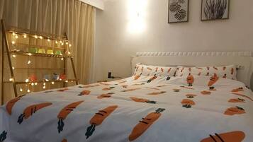 A bedroom with a bed, a bedside table, a lamp, and a wall-mounted shelf with lights.