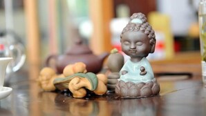 Une statue de Bouddha sur une table, entourée d’autres objets décoratifs.