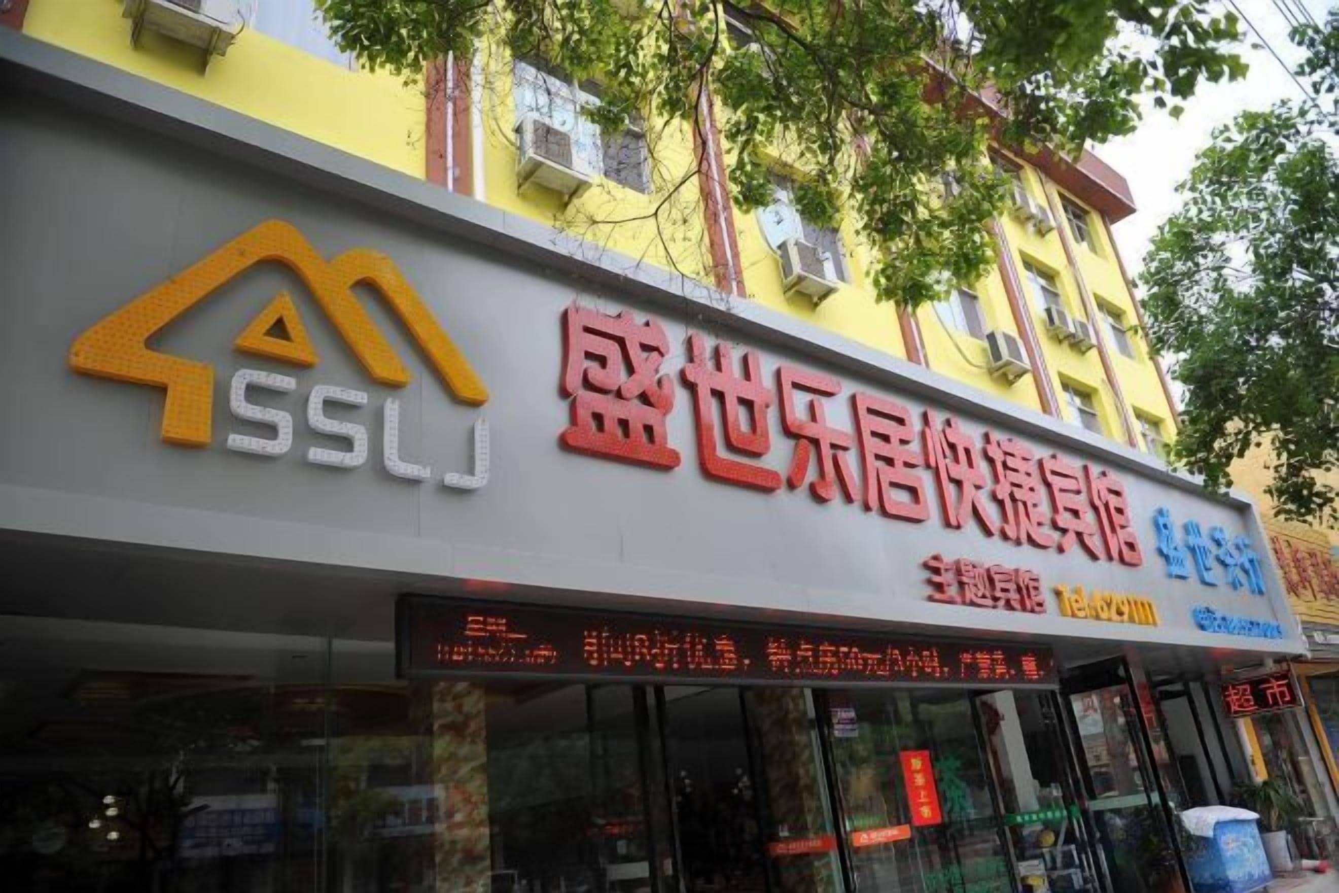 Un edificio con un letrero que dice 'SSLJ' y '盛世乐居快捷酒店', indicando que es un hotel.