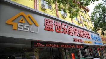 Un edificio con un letrero que dice 'SSLJ' y '盛世乐居快捷酒店', indicando que es un hotel.