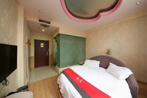 A hotel room with a bed, a TV, a wardrobe, and a door leading to another room. - AA Room (Suzhou)