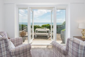 A room with a view of the sea, a table with chairs, and a sofa. - The Rath, Holiday Cottage Saundersfoot, Sleeps 6, 3 bedrooms,  bathrooms (SAUNDERSFOOT)