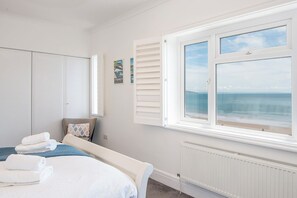 A bedroom with a bed, a wardrobe, a radiator, and a window with a view of the sea. - The Rath, Holiday Cottage Saundersfoot, Sleeps 6, 3 bedrooms,  bathrooms (SAUNDERSFOOT)