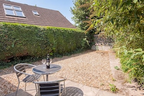 A patio with a table and chairs, a bottle of wine, and a glass. - The Rath Cottage, Holiday Cottage Saundersfoot, Sleeps 2, 1 bedrooms, bathrooms (SAUNDERSFOOT)