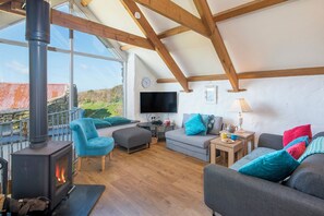 A cozy living room with a fireplace, comfortable seating, a flat-screen TV, and a scenic view. - The Roost, Holiday Cottage Whitesands Bay, near St Davids, Sleeps 5, 2 bedrooms,  bathrooms (Haverfordwest)