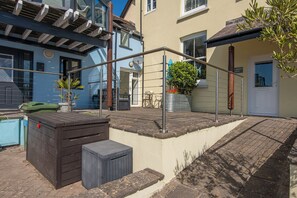 A residential area with a blue building, a door labeled 'ADJ. 2', and a small garden with a potted plant.