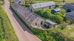 A rural property with stone buildings, a paved road, and surrounding fields. - The Stables and Bullpen, Holiday Cottage Castlemartin, Sleeps 6, 3 bedrooms,  bathrooms (Pembroke)