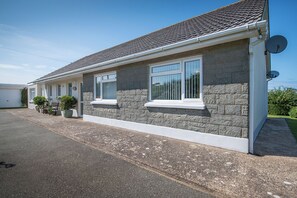 A two-story building with a stone facade, large windows, and a satellite dish. - Trefisheg Bungalow, Holiday home Strumble Head, Sleeps 6, 3 bedrooms,  bathrooms (Strumble Head)