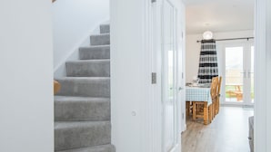 Eine Treppe führt zu einem Essbereich mit kariertem Tisch und Stühlen.