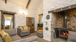 A cozy living room with a stone fireplace, a television, and comfortable seating. - Vagwr Eilw Cottage, Holiday Cottage Llanhowell, near Abereiddy, Sleeps 6, 3 bedrooms,  bathrooms (Haverfordwest)