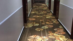 A hallway with a patterned floor and wooden walls.