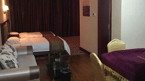 A hotel room with a bed, a sofa, a small table, and a chair.