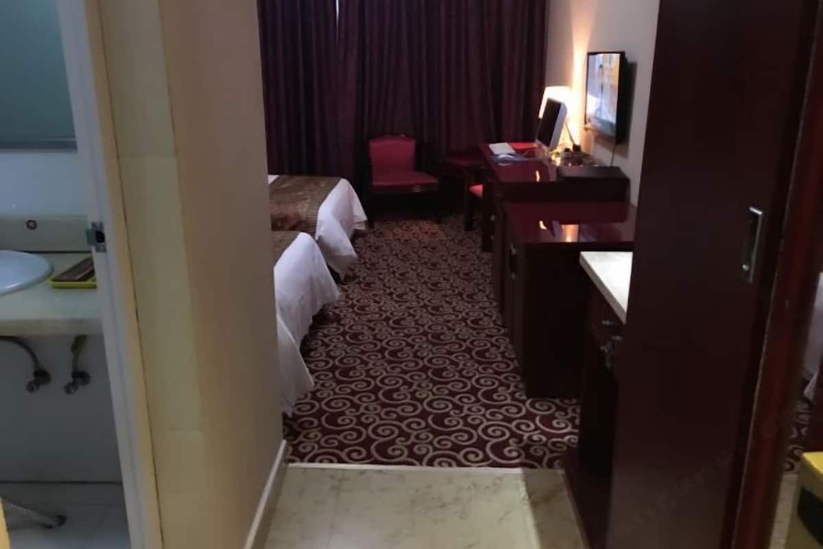 Una habitación de hotel con una cama, un escritorio, una silla y una mesita.