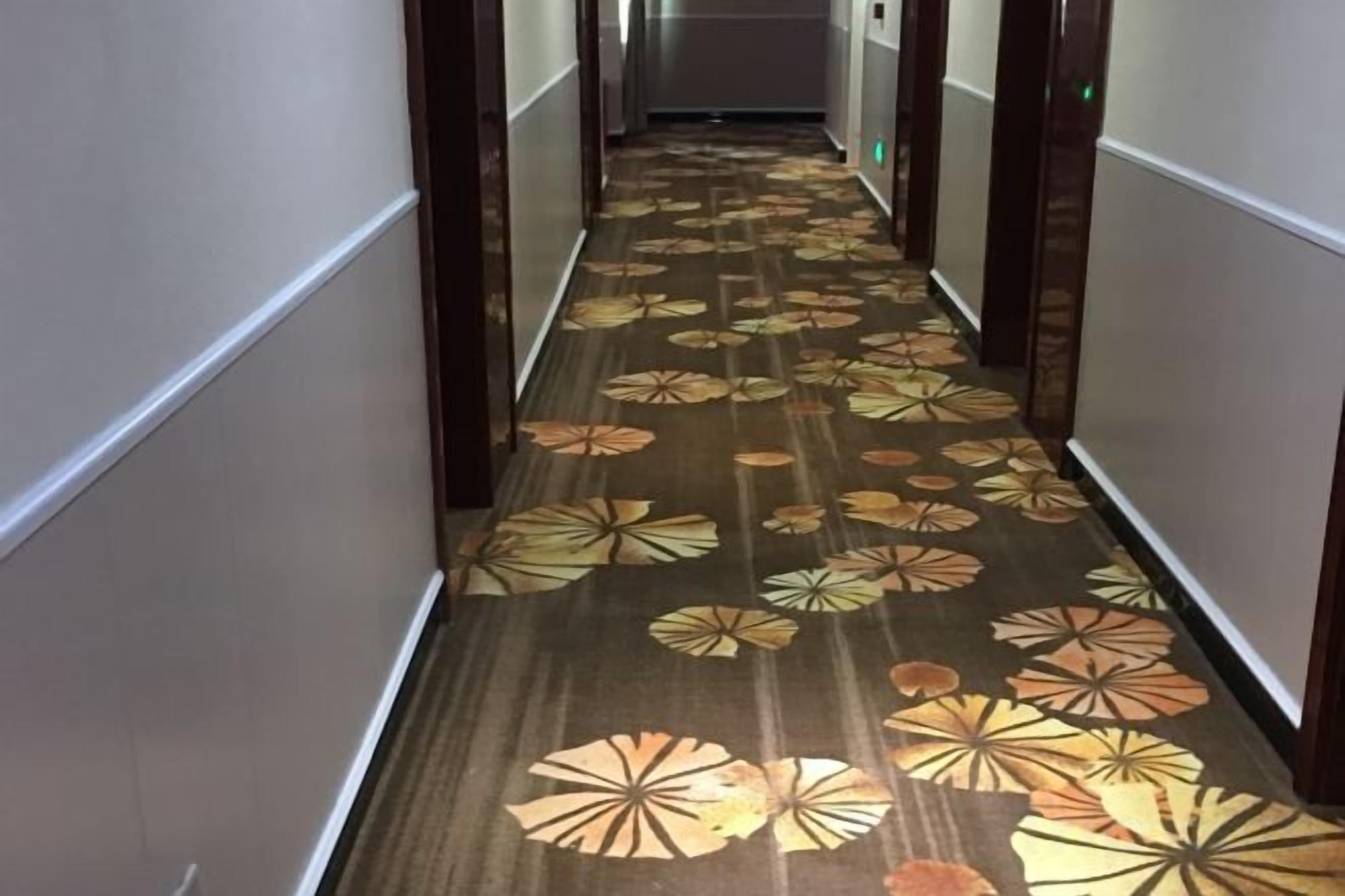 Un couloir avec un tapis à motifs et des murs en bois.