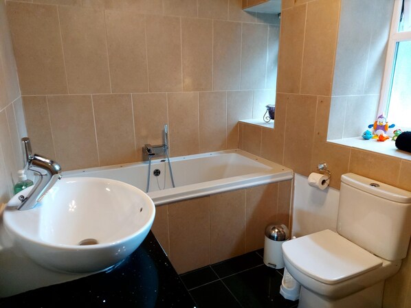 A bathroom with a bathtub, toilet, and sink.