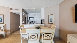 A compact kitchen with white cabinets, a microwave, and a stove.