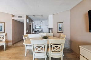 A compact kitchen with white cabinets, a microwave, and a stove.