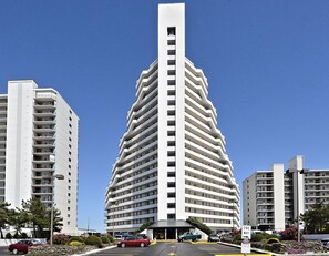Un hôtel moderne à plusieurs étages, doté d’un design original aux lignes angulaires, avec une entrée centrale et de nombreux balcons.