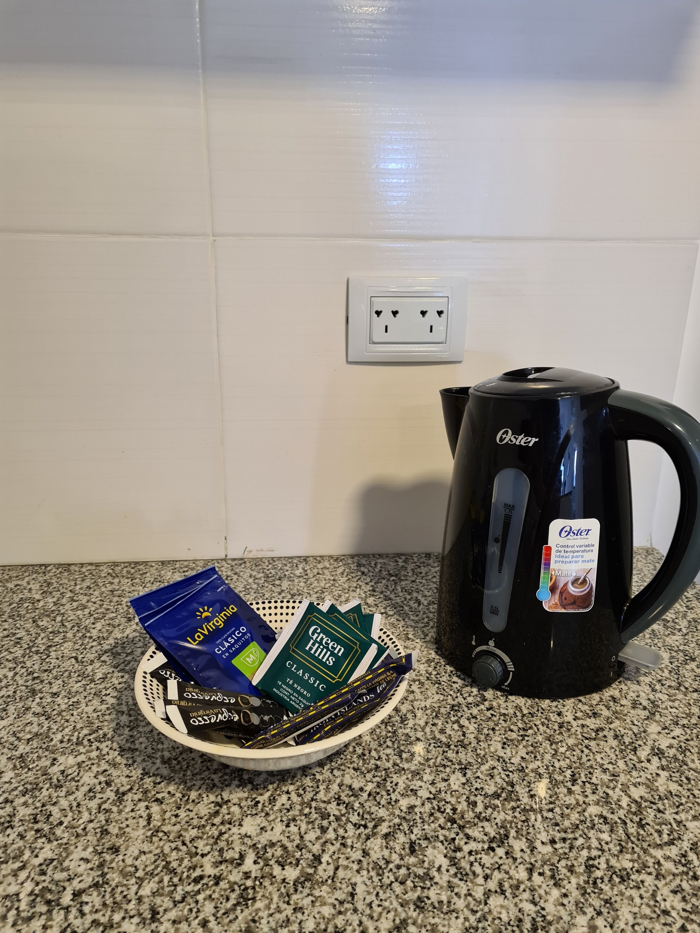 Eine Küche mit einer schwarzen Oster-Kaffeemaschine und einer Kaffeekapseln-Platte.