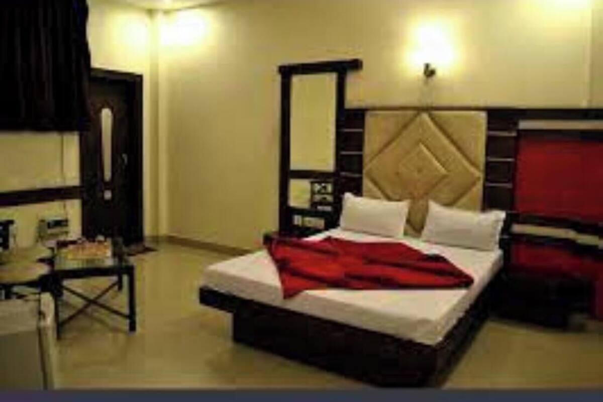 A hotel room with a bed, a desk, and a wardrobe.
