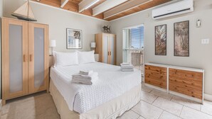 A bedroom with a bed, wooden wardrobe, and a radiator.