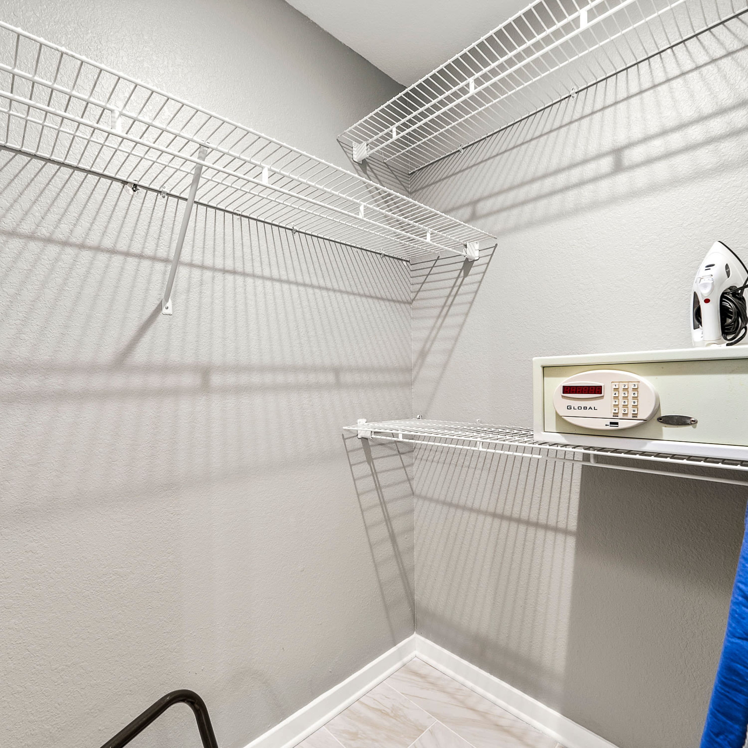 A laundry room with metal drying racks, a wall-mounted heater, and a security keypad.