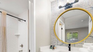 Une salle de bain équipée d’une baignoire, de toilettes et d’un meuble-lavabo avec un miroir.