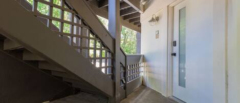 Un escalier avec une rampe en métal menant à une porte blanche.