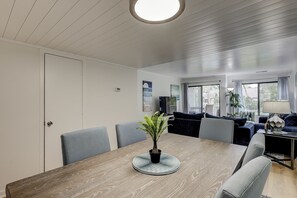 Una sala de estar moderna con una mesa de comedor, sofás y un televisor.
