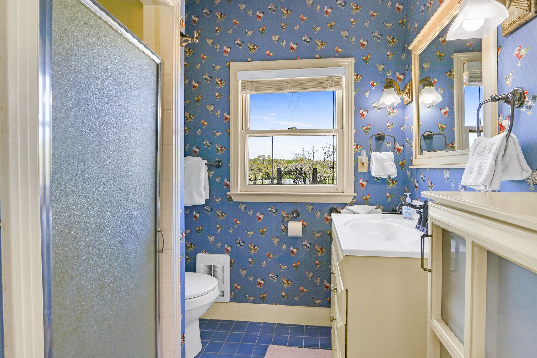 Een badkamer met toilet, wastafel en raam.