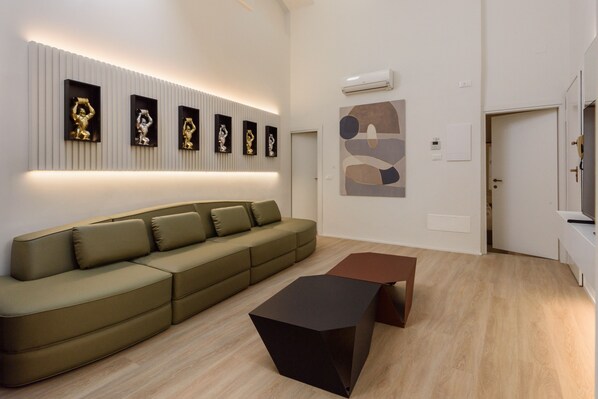 A modern living room with a sectional sofa, a coffee table, and wall-mounted art.