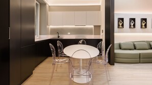 A modern kitchen with a round dining table and chairs, a built-in oven, and a light-colored countertop. - Anguillara Full Design by Mmega (Florence)