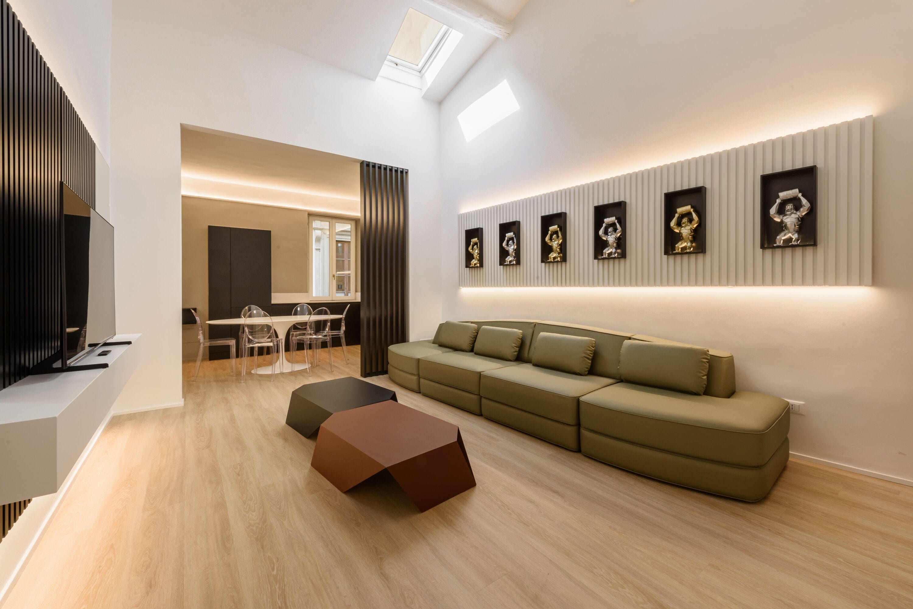 A modern living room with a sectional sofa, a coffee table, and a dining area with chairs and a table.