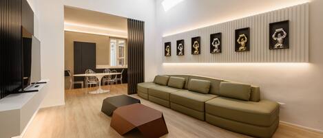 A modern living room with a sectional sofa, a coffee table, and a dining area with chairs and a table.