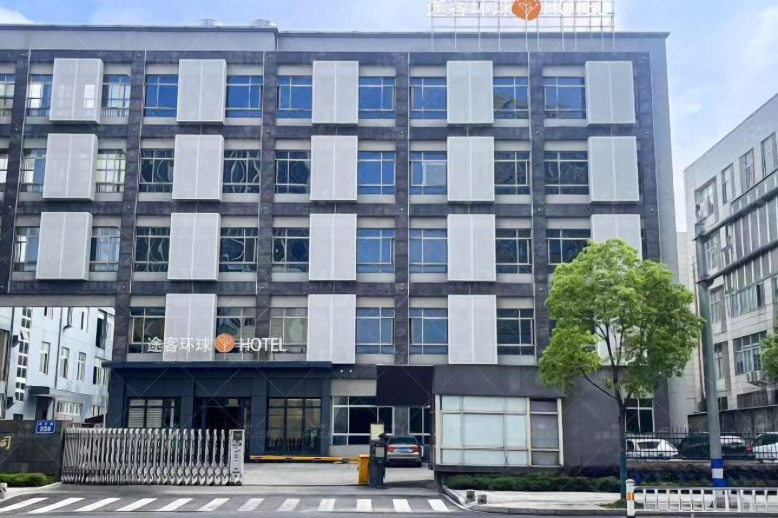 Um hotel moderno com fachada simétrica, janelas amplas e entrada visível.