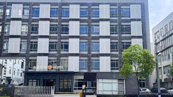 Um hotel moderno com fachada simétrica, janelas amplas e entrada visível.