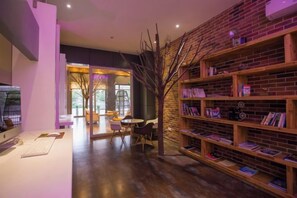 A modern interior with a brick wall, bookshelves, a desk, and a seating area. - Tuke Global Hotel (Wenzhou Louqiao South Railway Station) (Wenzhou)
