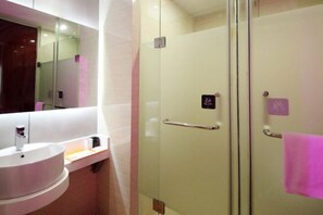 A modern bathroom with a glass shower enclosure, a white sink, and a mirror above the sink. - Tuke Global Hotel (Wenzhou Louqiao South Railway Station) (Wenzhou)