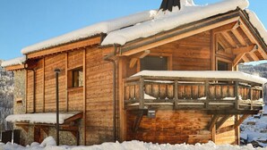 Eine Holzhütte mit Balkon, umgeben von Schnee.
