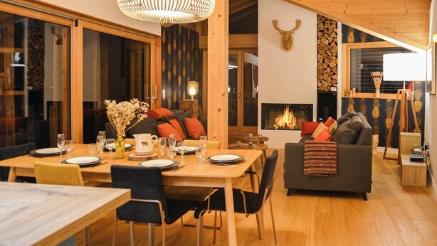 Ein gemütliches Wohnzimmer mit Kamin, Holzmöbeln und einem großen Fenster.