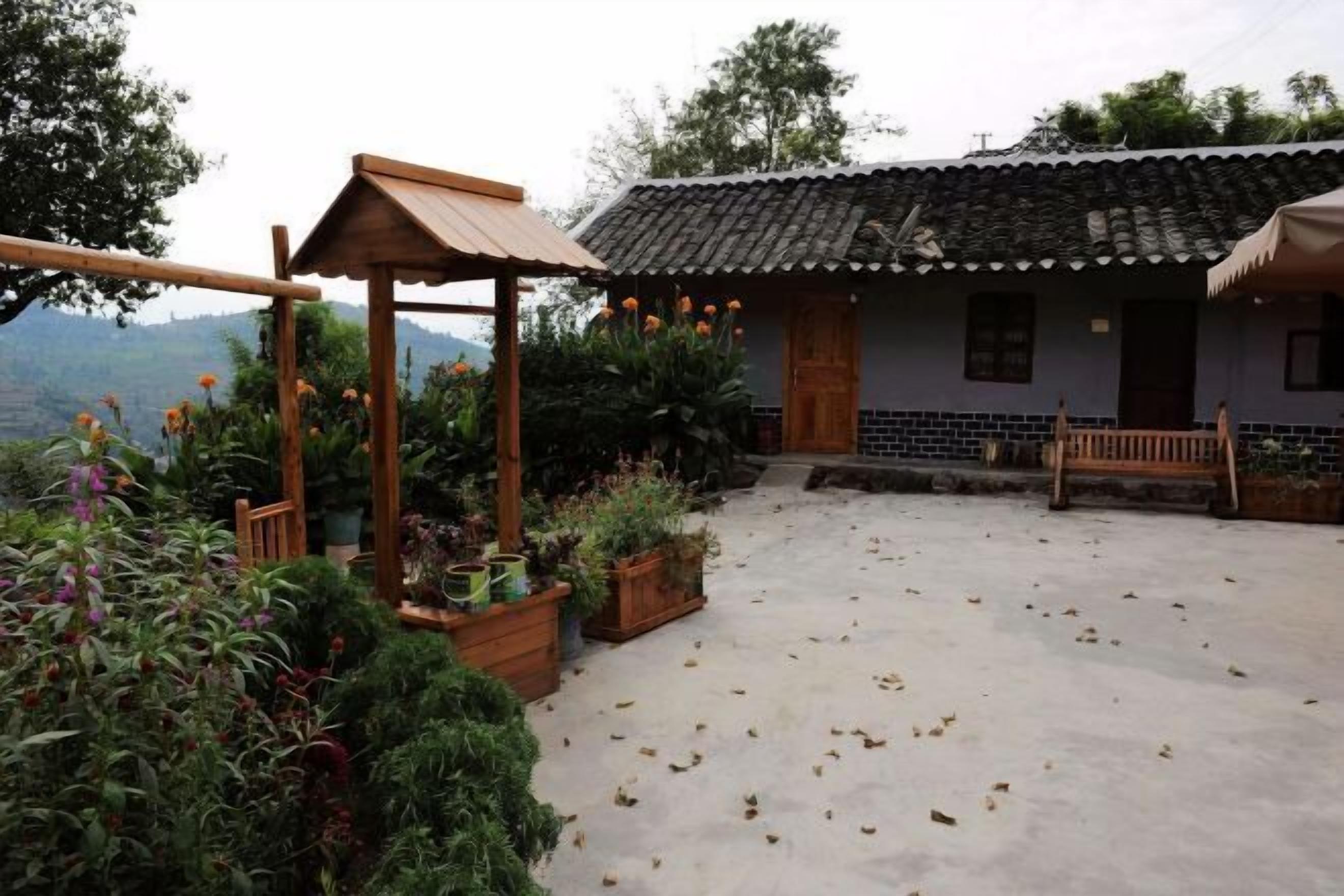 A traditional house with a tiled roof, a wooden porch, and potted plants.