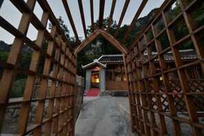 A traditional wooden gate leading to a building with a tiled roof and a stone pathway. - Yuqingfang Hongdu Hostel (Yuqing)