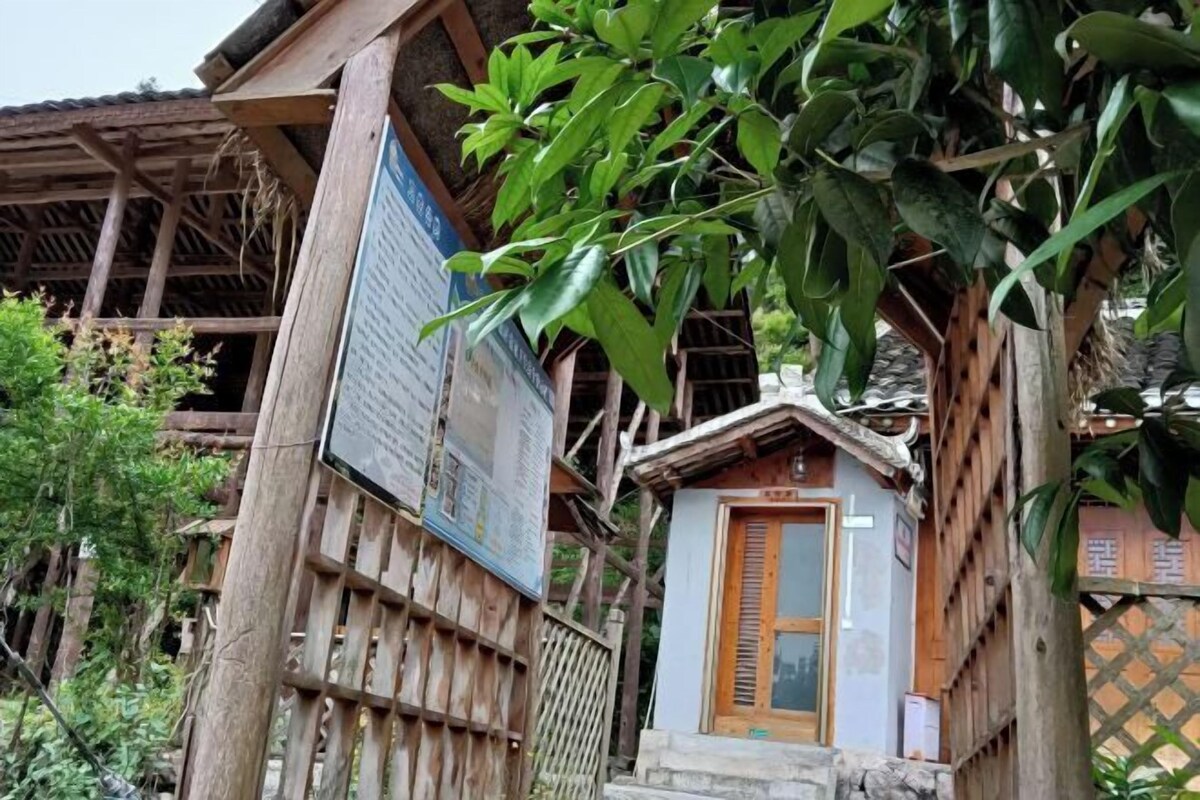 A traditional wooden house with a small porch and a signboard.