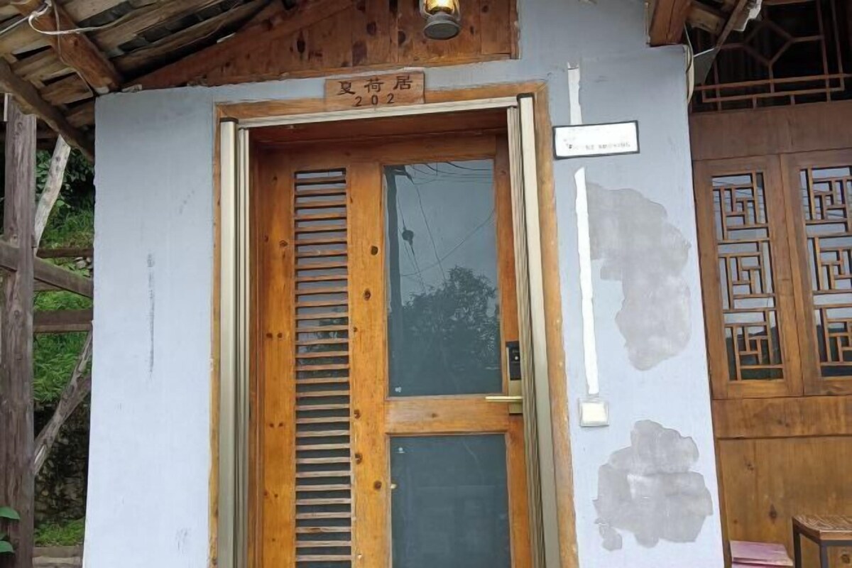 A wooden door with a sign above it, a window with wooden shutters, and a traditional Chinese lattice design on the wall.
