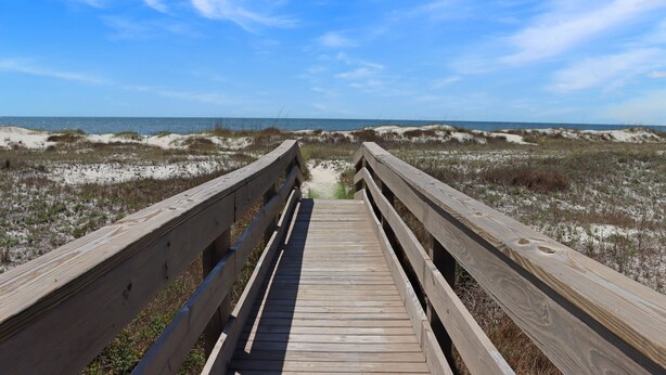 A wooden boardwalk leading to a beach with sand dunes and a clear blue sky. - Beachfront, Next to Pool, Hot Tub! "Sandpiper" - Club at Cape San Blas (Cape San Blas)