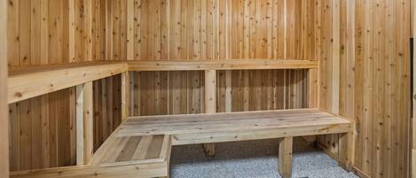 A sauna room with wooden walls and benches.