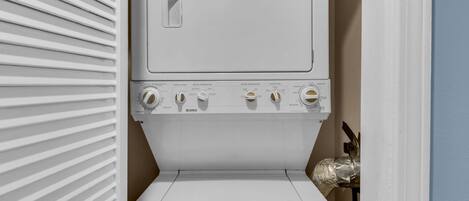 A front view of a front-loading washing machine with control knobs for temperature and settings.